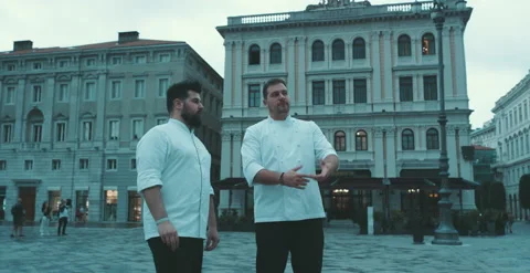 Two chefs have a conversation on city square Stock Footage 204973355