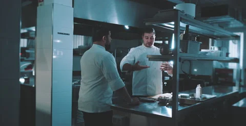 Two chefs have a conversation in kitchen Stock Footage 204973130
