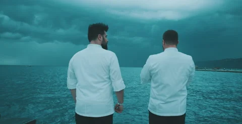 Two chefs have a conversation by the water Stock Footage 204973543