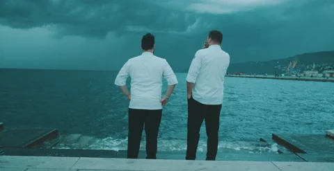 Two chefs have a conversation by the water Stock Footage 204973559