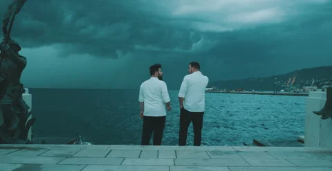 Two chefs have a conversation by the water Stock Footage 204973737