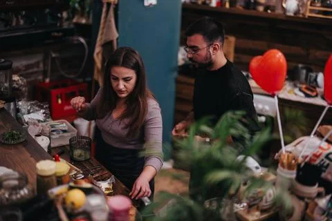 Two chefs preparing meals in a lively kitchen setup with decorations Stock Photos