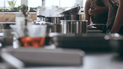 Two chefs talking by their work stations and counter with pots and pans in inter Stock Footage 199463686