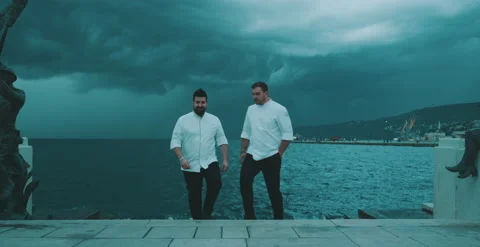 Two chefs walk away from the waters edge Stock Footage 204973546