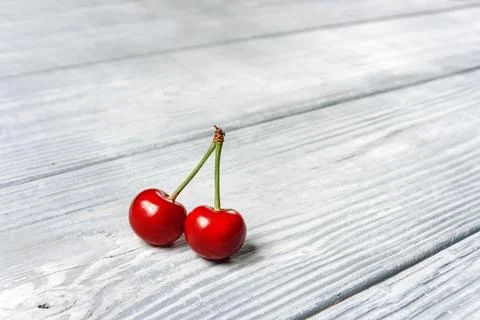 Two cherries close-up on a background of boards with copy space. Stock Photos
