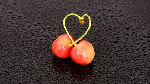 Two cherries with drops tied into a heart love. Stock Footage 157164671