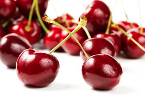 Two cherries in front of many Stock Photos