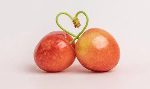 Two cherries with a heart Stock Photos