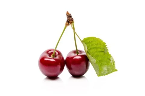 Two Cherry berries with green leaf isolated on a white background Stock Photos