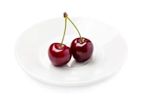 Two Cherry berries on a white plate isolated on white background cutout Stock Photos