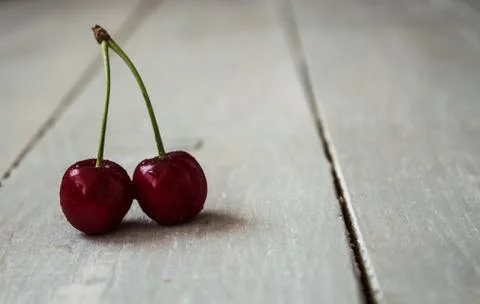 Two cherry on light wooden background Stock Photos