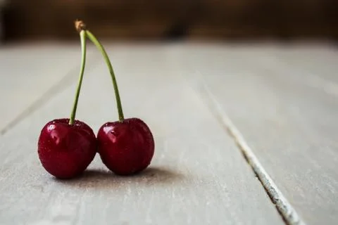 Two cherry on light wooden background Stock Photos