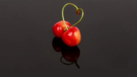 Two cherry love sign. Sweet cherry love sign on black background. Stock Footage 239232268