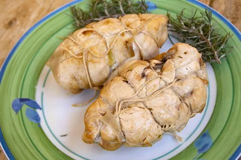 Two chicken breasts tied with kitchen twine resting on plate with rosemary .. Stock Photos