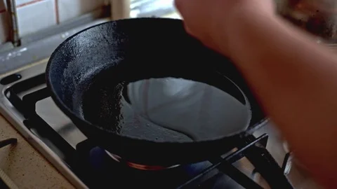 Two chicken eggs fried in a black frying pan Vídeos de archivo 70643571