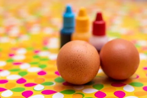 Two chicken eggs on a multi colored vibrant custom background. Red yellow and Stock Photos