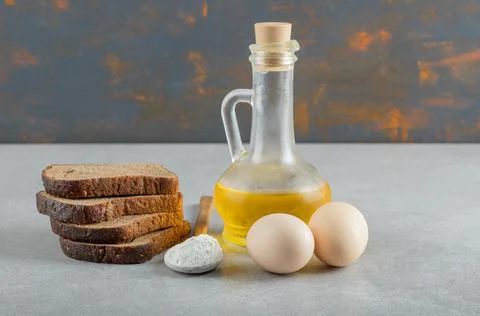 Two chicken eggs with slices of bread and bottle of oil Stock Photos