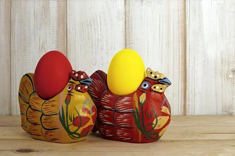 Two chicken made of wood with easter eggs Stock Photos