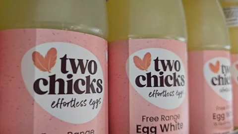 Two Chicks brand liquid egg whites in clear plastic bottles with pink labels Video stock 311576091