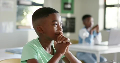 Two child boys watching in class, camera shifting to front boy leaning, Stock Footage 335747180