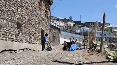 Two child drive bycicle in Khinalig village in Azerbaijan Stock Footage 249171863