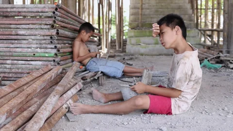 Two child laborers carrying construction materials inside an unfinished building Stock Footage 336950861