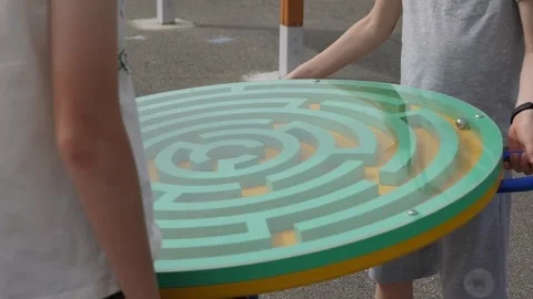 Two children are playing a giant maze game in the park. Stock Footage 278650782