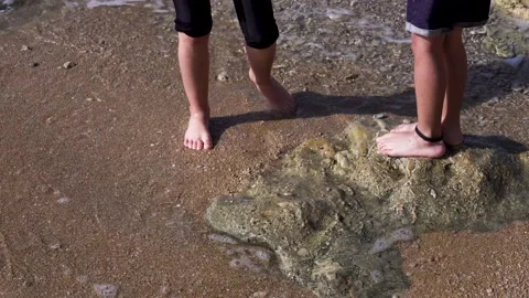 Two children are standing on the beach,The water covers the feet 스톡 동영상 208038580