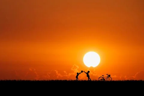 Two children are throwing balls in the meadow happily. Children's happiness c Stock Photos