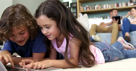 Two children are using computer while parents are using pad Video stock 62828825