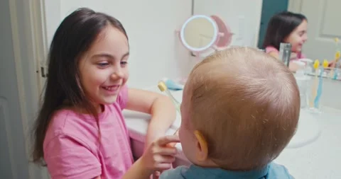 Two children brush their teeth with toothbrushes in the bathroom. Stock Footage 239015708