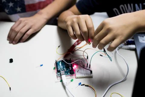 Two children build a prototype circuit with a red laser controlled by a micro Stock-Fotos