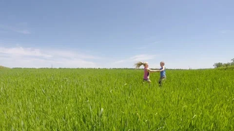 Two children circling the meadow. Video stock 51401686