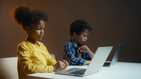 Two children coding on laptops, giving high five after successful program start Stock Footage 308000436