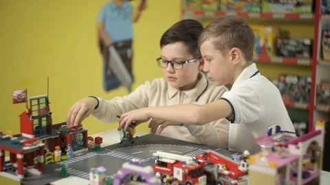 Two children, developing, build from the plastic constructor of the building Stock Footage 87958356