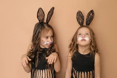 Two children with Easter bunny face paint and black rabbit ears. Stock Photos