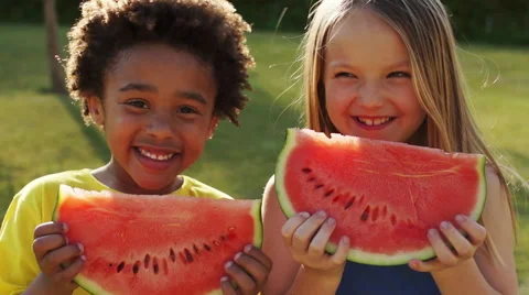 Two children eating water melon in park. Vidéo 43673519