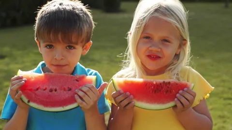 Two children eating water melon in park. Stock Footage 43673530