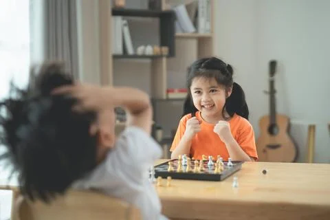 Two Children Engaged in a Friendly Chess Game Expressing Excitement and Joy.. 写真素材