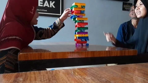 Two children enjoying playing Jenga in a steakhouse Stock Footage 292960931