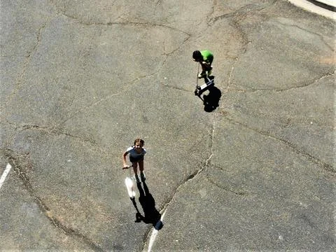 Two children frolic as a drone passes overhead Stock Photos