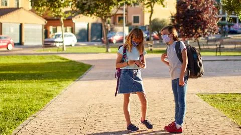 Two children going back to school during covid-19 pandemic. School child wear Stock Photos