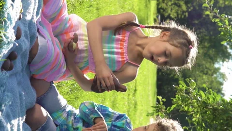 Two children having fun and eating chocolate easter eggs in garden Stock Footage 264963617