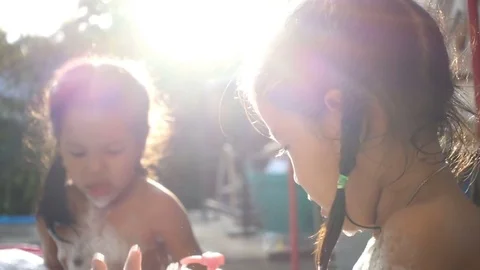 Two children having fun to bath and play with foam in outdoor Stockbeeldmateriaal 79473887