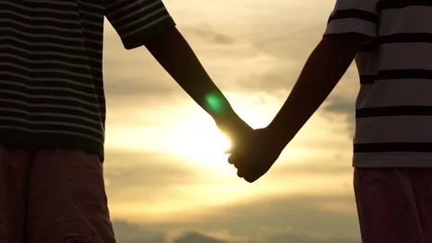 Two children holding hands at sunset close up 库存影片 337748407