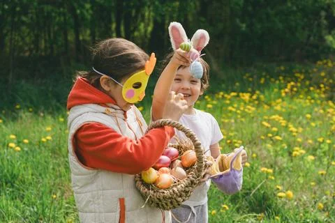 Two children hunt for Easter eggs in a spring garden. Easter tradition Stock Photos