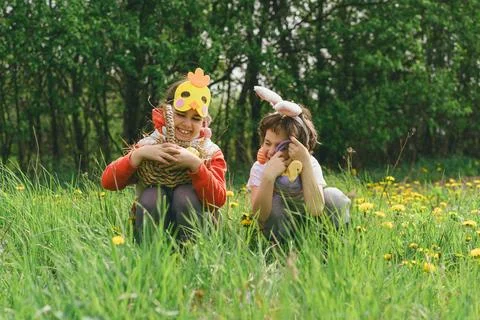 Two children hunt for Easter eggs in a spring garden. Easter tradition Stock Photos