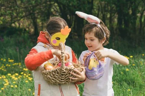 Two children hunt for Easter eggs in a spring garden. Easter tradition Foto stock
