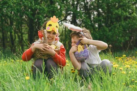 Two children hunt for Easter eggs in a spring garden. Easter tradition Foto stock
