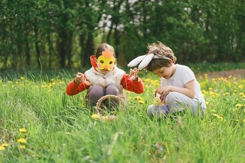 Two children hunt for Easter eggs in a spring garden. Easter tradition Foto stock